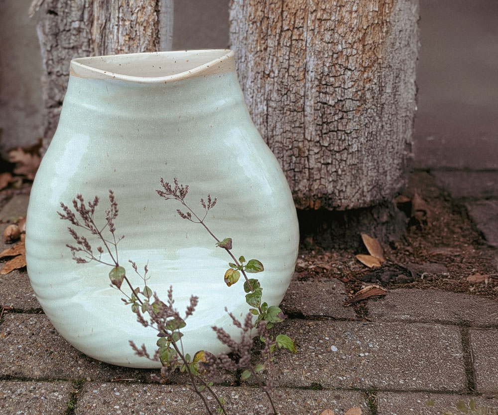 belly-vase-keramik-schwangerschaftsbauch Auf dem Bild sieht man eine belly vase , die ein Abdruck eines Babybauchs ist. Die Keramikvase ist Mintfarben glasiert.